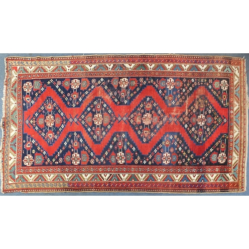 792 - Rectangular red and blue ground rug having an all over geometric design, 320cm x 178cm