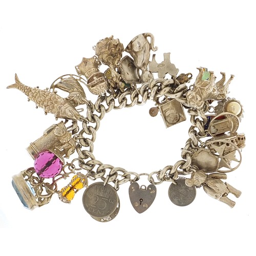 1752 - Heavy silver charm bracelet with a selection of mostly silver charms including articulated teddy bea... 