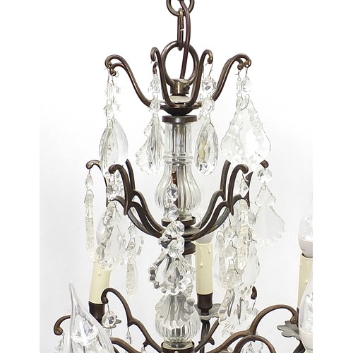 854 - Bronzed eight branch three tier chandelier with cut glass drops, 73cm high excluding the fitting