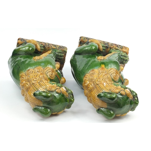 106 - Large pair of Chinese floor standing pottery seated lions having a sancai type glaze, each 59cm high