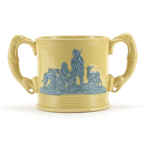 562 - Victorian twin handled cup decorated in relief with huntsmen and hounds, 22cm wide