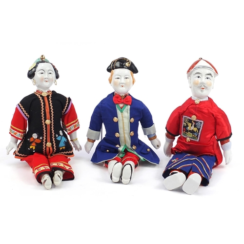 865 - Three Chinese porcelain dolls with cloth bodies and tapestry clothing, the largest 41cm high