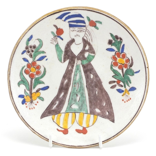 73 - Turkish Kutahya pottery dish hand painted with a figure, 14.5cm in diameter