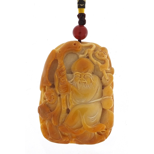 855 - Chinese hardstone pendant carved with an elder holding a staff on cord, the pendant 6.5cm high