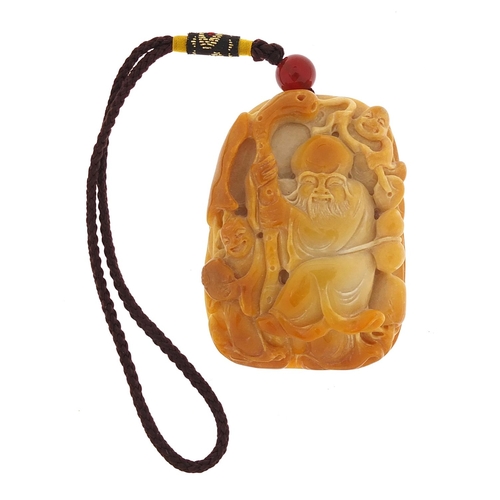 855 - Chinese hardstone pendant carved with an elder holding a staff on cord, the pendant 6.5cm high