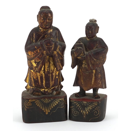 853 - Two Chinese partially gilt lacquered wood carvings of attendants, the largest 18.5cm high