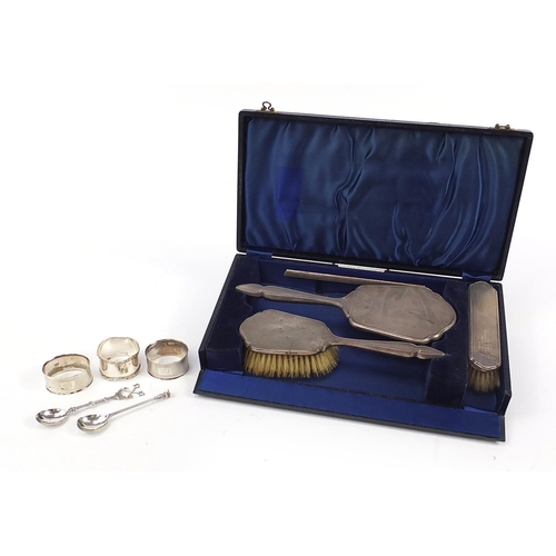 2132 - Silver objects comprising four piece dressing table set with fitted case, three napkin rings and two... 