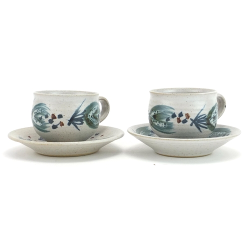 465 - Marianne de Trey, pair of studio pottery cups and saucers hand painted with stylised motifs, impress... 