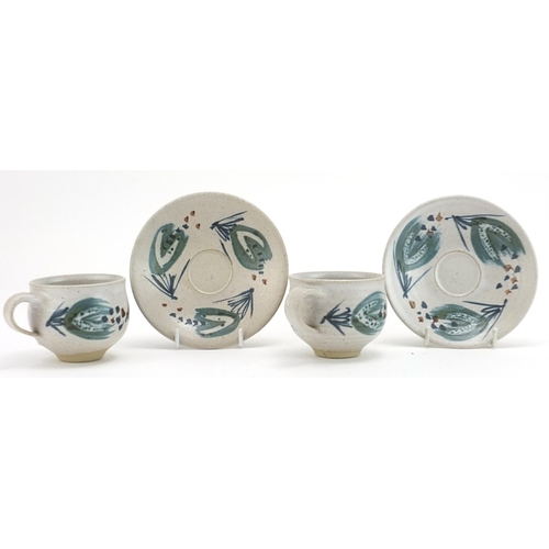 465 - Marianne de Trey, pair of studio pottery cups and saucers hand painted with stylised motifs, impress... 