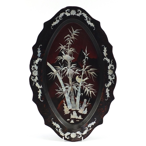 1016 - Oval Chinese lacquered and mother of pearl tray decorated with birds amongst bamboo, 48cm wide