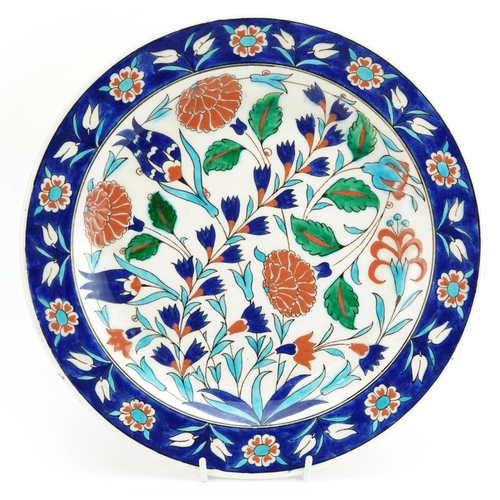 516 - Kutahya, Turkish pottery charger hand painted with flowers, signed Saylam Ciri, 30.5cm in diameter