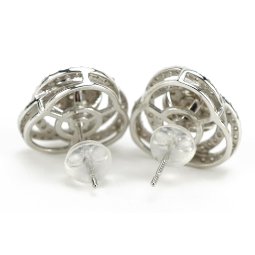 1405 - Pair of 18ct white gold swirling diamond cluster stud earrings, total diamond weight approximately 1... 