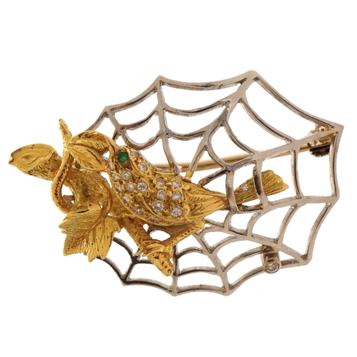 1416 - 18ct yellow and white gold bird and spider web brooch set with diamonds and an emerald, 4.5cm wide, ... 