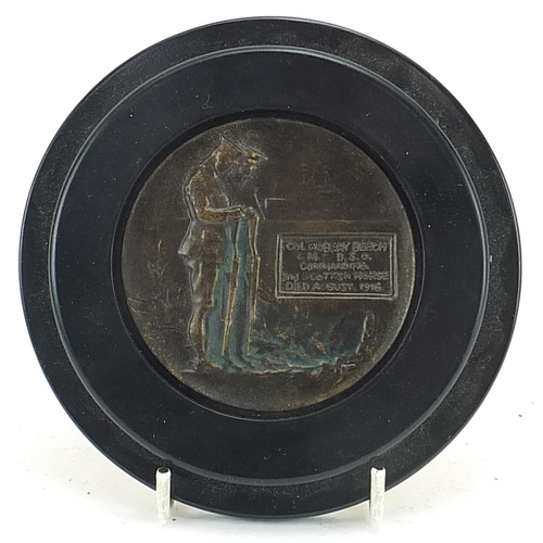 587 - Military interest bronzed plaque with ebonised frame, 13cm in diameter