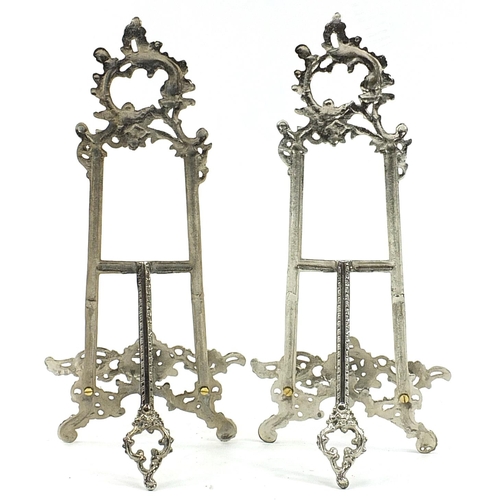 540 - Pair of Rococo style silvered metal easel stands, 40cm high