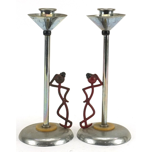 69 - Pair of Art Deco partially painted chrome candlesticks in the form of a figure leaning against a lam... 