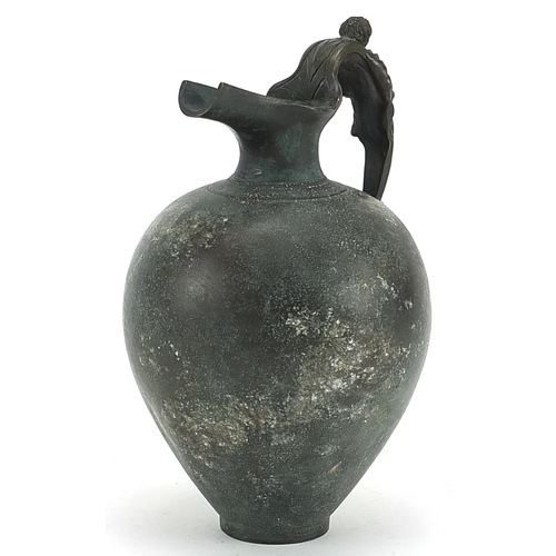 155 - Antique patinated bronze spouted vessel with figural handle, 19.5cm high