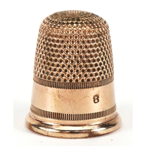 1012A - Yellow metal thimble housed in a tooled leather box in the form of a chest, the thimble 2.1cm high