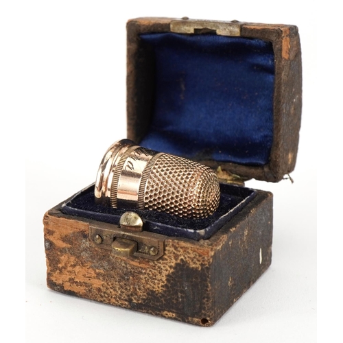 1012A - Yellow metal thimble housed in a tooled leather box in the form of a chest, the thimble 2.1cm high