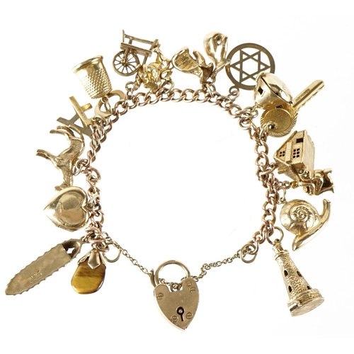 1411 - 9ct gold charm bracelet with a collection of mostly 9ct gold charms, 49.0g