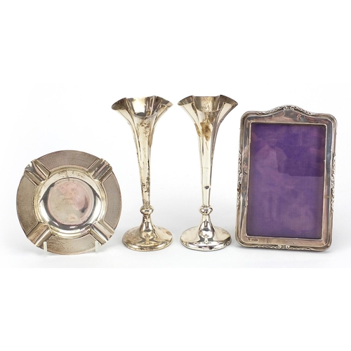 2135 - Silver items comprising pair of Mappin & Webb bud vases, easel photo frame and circular ashtray, the... 