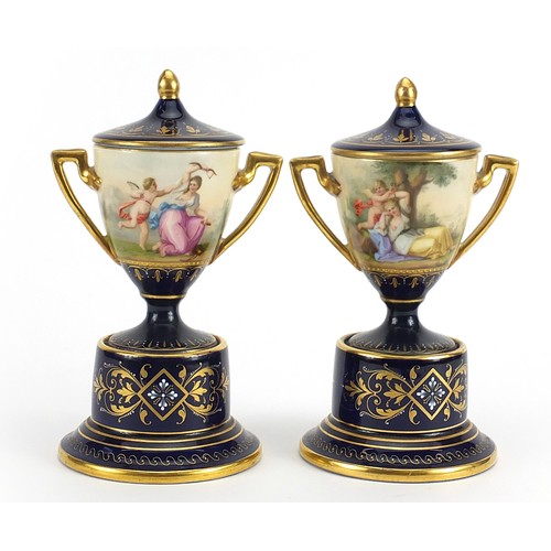 347 - Pair of Royal Vienna porcelain pedestal vases and covers with twin handles, each hand painted with c... 