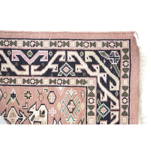 770 - Rectangular pink and blue ground rug having an all over geometric design, 130cm x 75cm