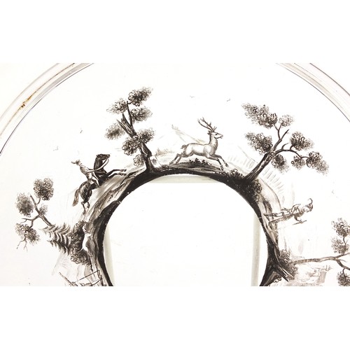 229 - Bohemian glass cabaret tray hand painted with huntsmen and deer in a landscape, 23.5cm in diameter