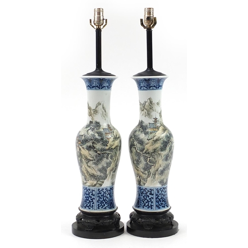 389 - Pair of Chinese porcelain baluster vase table lamps hand painted with figures and buildings amongst ... 