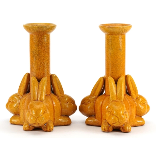 128 - Manner of Christopher Dresser, pair of Arts & Crafts yellow glazed candlesticks with three rabbits, ... 