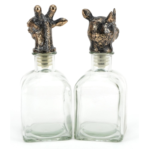 808 - Pair of glass decanters with rhinoceros and giraffe head stoppers, the largest 24cm high