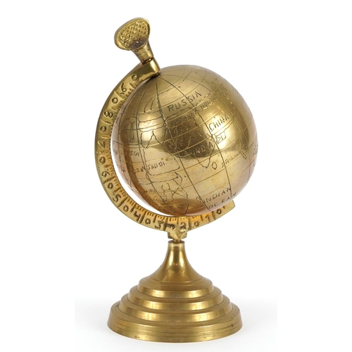 1047 - Brass rotating desk globe on stepped base, 23cm high