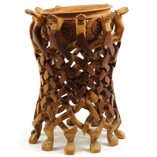 888 - African hardwood bowl carved with flowers housed in a puzzle design stand carved with animal heads, ... 