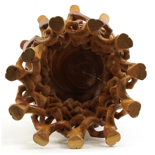 888 - African hardwood bowl carved with flowers housed in a puzzle design stand carved with animal heads, ... 