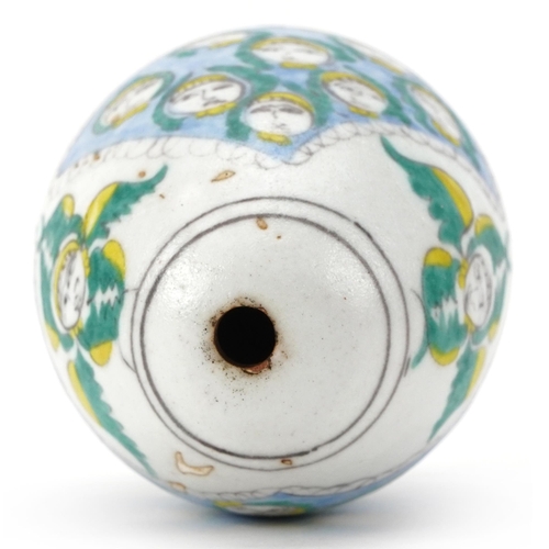 273 - Turkish Armenian pottery hanging ball hand painted with mythical faces, 10cm high