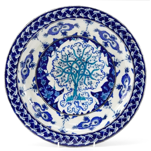 153 - Turkish Iznik pottery charger hand painted with a tree and flowers, 35cm in diameter