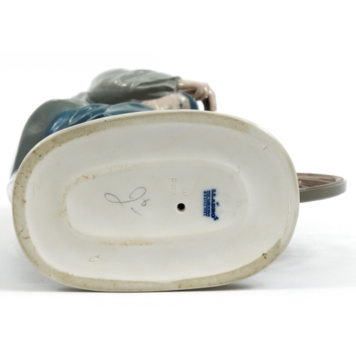 977 - Lladro porcelain figure of a man at a grinding wheel, impressed D-22A to the base, 29cm high