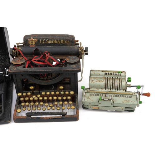 1183 - Three vintage typewriters and a Schubert Rastatt Exactus calculator comprising L C Smith & Bros, Oli... 