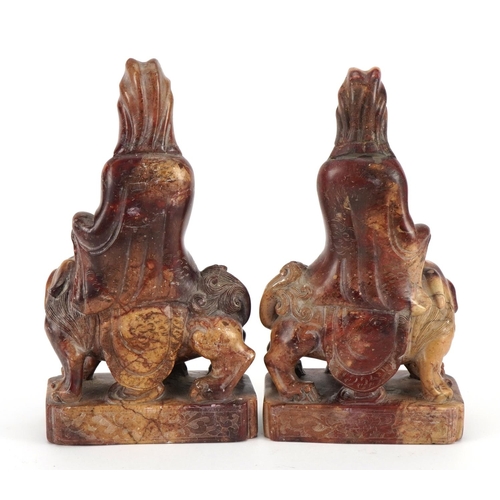 77 - Good pair of Chinese soapstone carvings of Guanyin seated on a mythical animal, each 21cm high