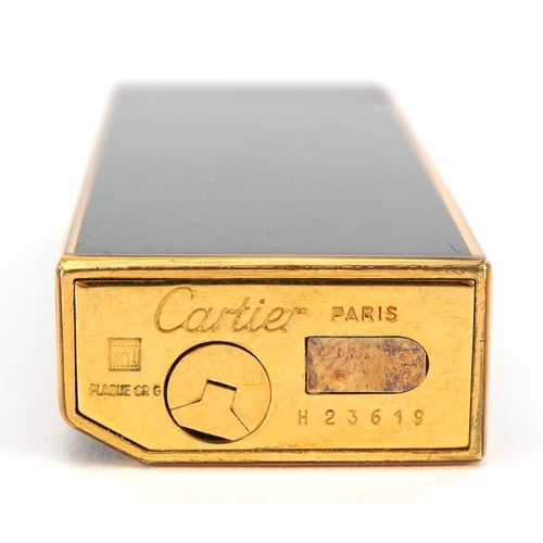 63 - Cartier gold plated and black enamel pocket lighter numbered H23649, 7cm high