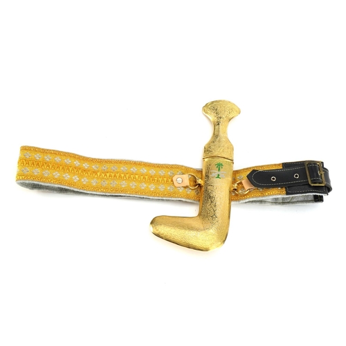 815 - Omani ceremonial gilt metal jambiya dagger on embroidered belt, the dagger 27cm high