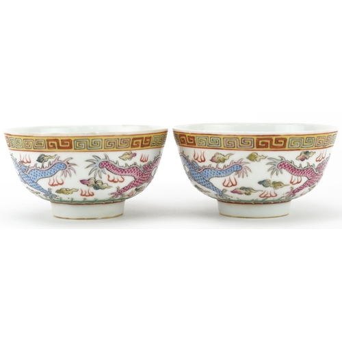 198 - Pair of Chinese porcelain bowls hand painted in the famille rose palette with dragons chasing the fl... 