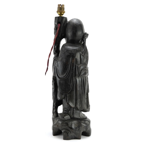 997 - Chinese root wood lamp base carved in the form of an elder holding a staff and fruit, 49cm high