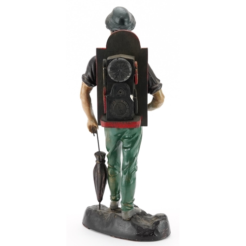 692 - Novelty painted spelter table clock in the form of a gentleman with an umbrella, 43.5cm high