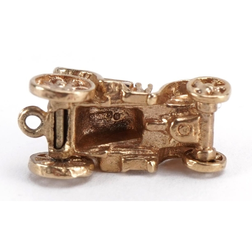 2085 - 9ct gold classic car charm with rotating wheels and enamelled seat, 1.7cm wide, 2.8g