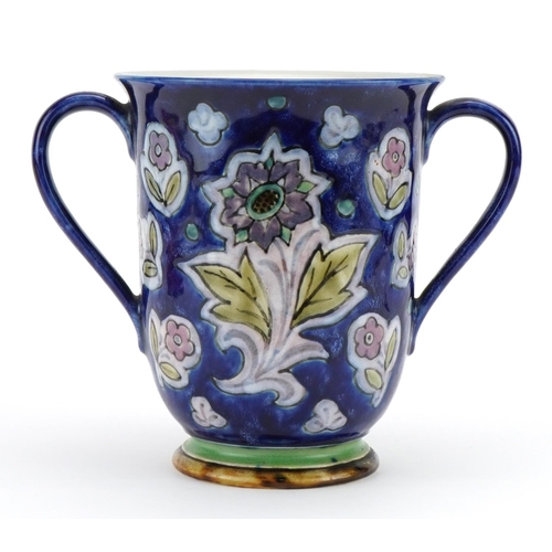 487 - Doulton stoneware loving cup with twin handles hand painted with stylised flowers, 18.5cm high