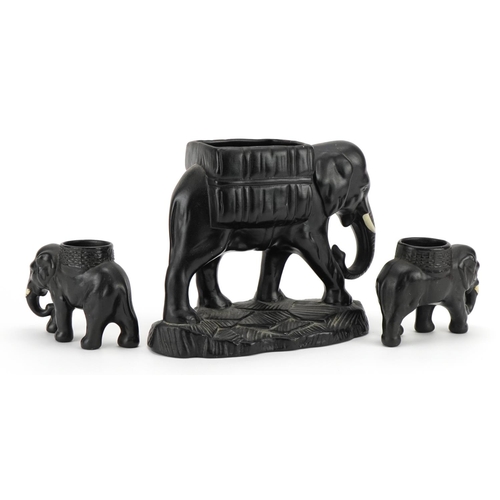 786 - Three early 20th century black painted pottery elephant design planters, the largest 21cm in length