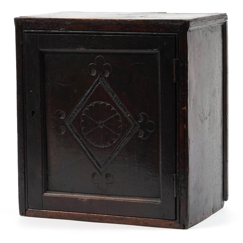 312 - 18th century carved oak spice cupboard with hinged door opening to reveal nine various sized drawers... 