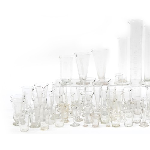 553 - Large collection of antique and later medical interest glass measures, the largest 47cm high