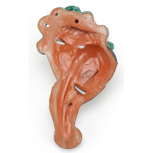 367 - Goldschneider, Austrian Art Deco pottery face mask of a female holding a mask, 22cm high